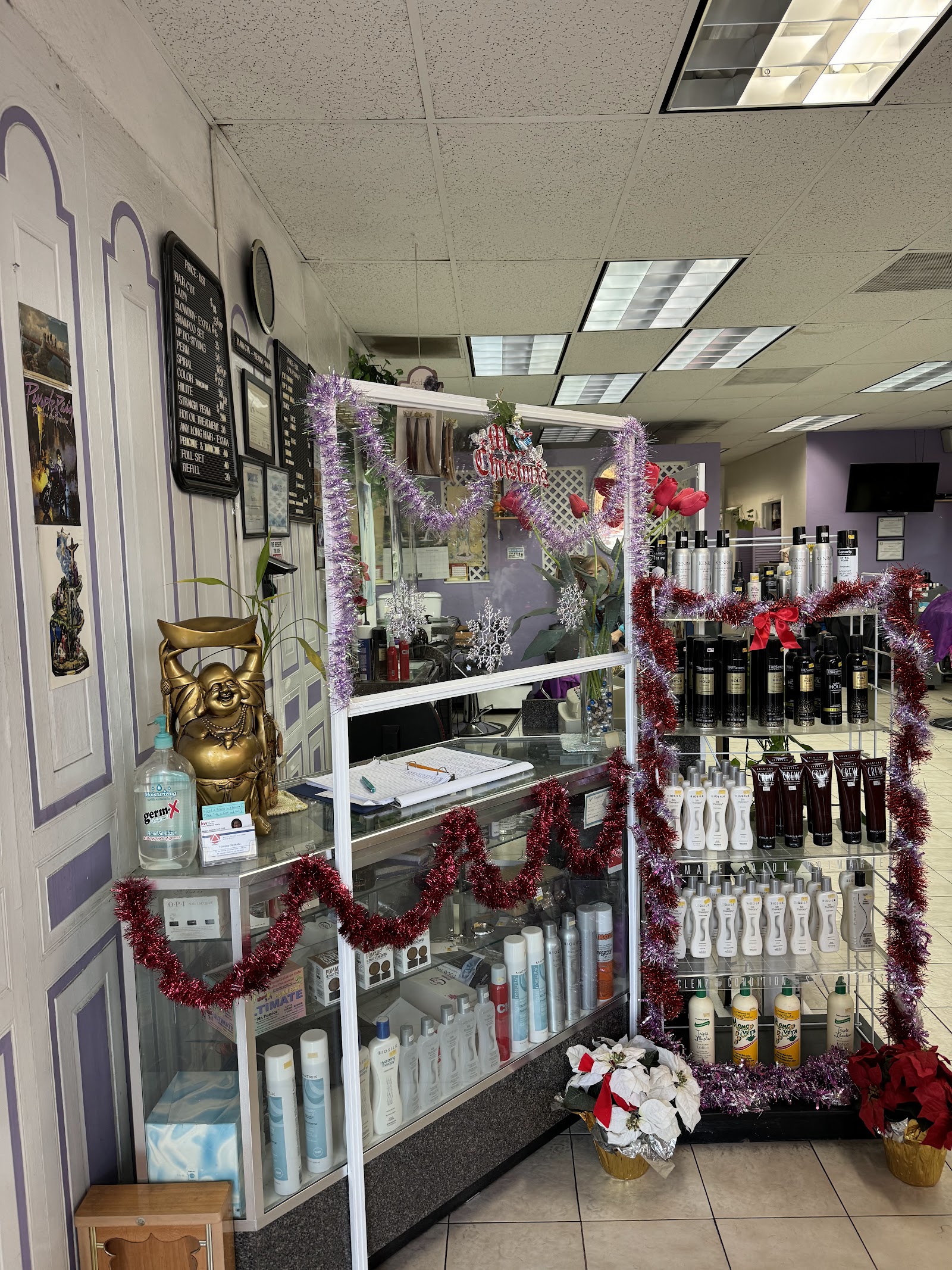 The glass front desk with a gold laughing-Buddha statue, hair-care products on the display shelves.