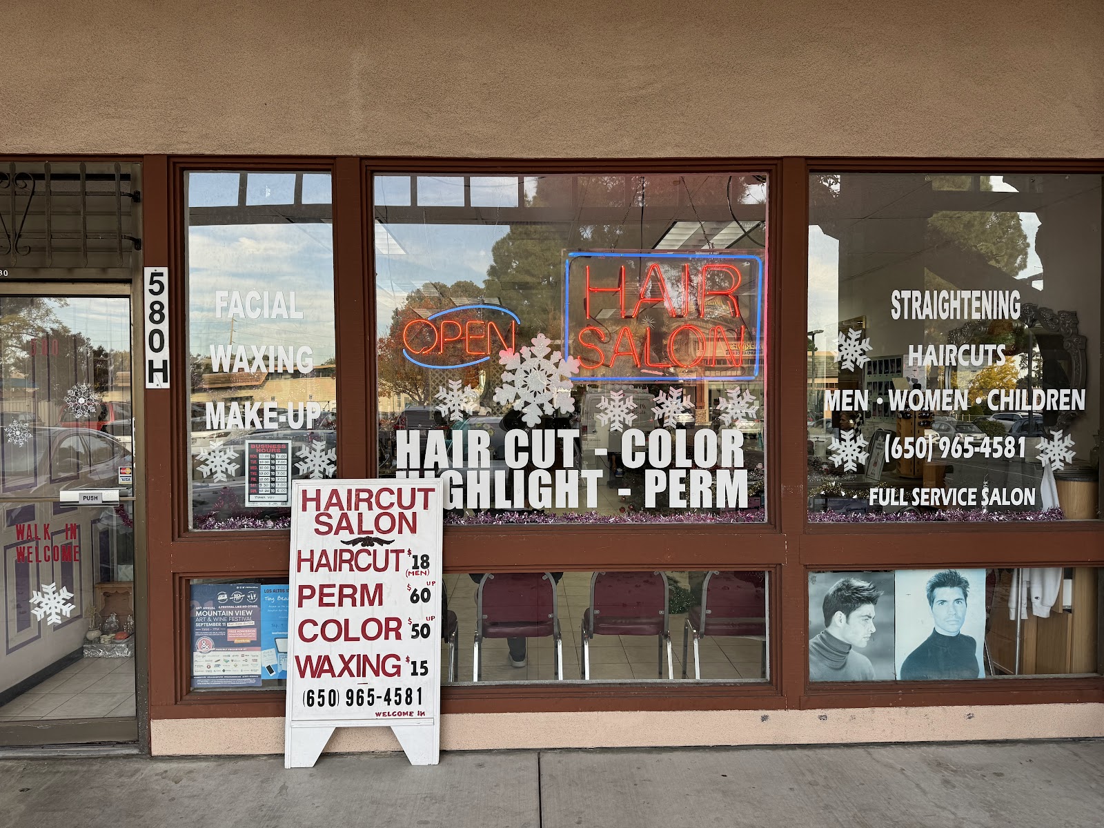 The Haircut Beauty Salon storefront on N Rengstorff Avenue, with neon HAIR SALON sign in the window and a sidewalk sandwich-board listing prices.